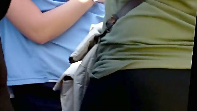 A hot brunette at a concert with black spandex and a juicy big ass