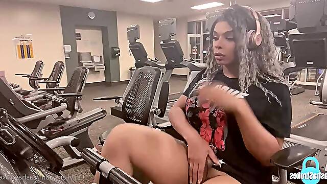 Using her sex toy to shoot a cumshot while working out in the gym