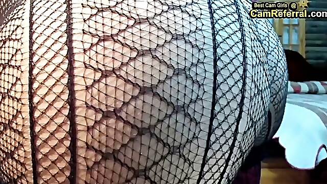Big ass bitch in black fishnets is riding a black dildo during a live cam show