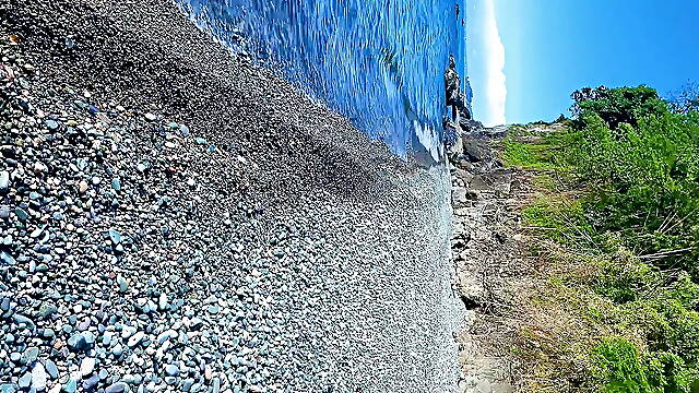 Guy jerking off dick on a nudist beach and a passerby joined him