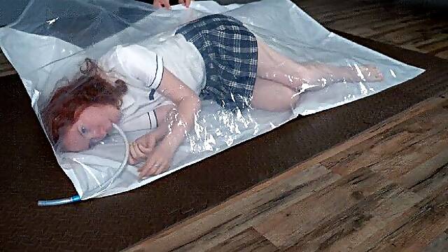 A schoolgirl in a vacuum bag and a hand pump